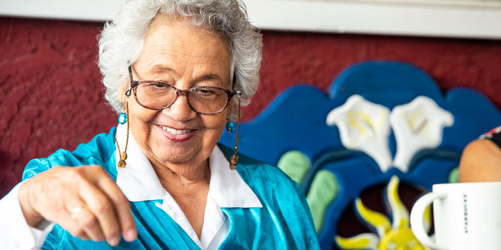 A senior woman with eyeglasses putting a jigsaw puzzle together.